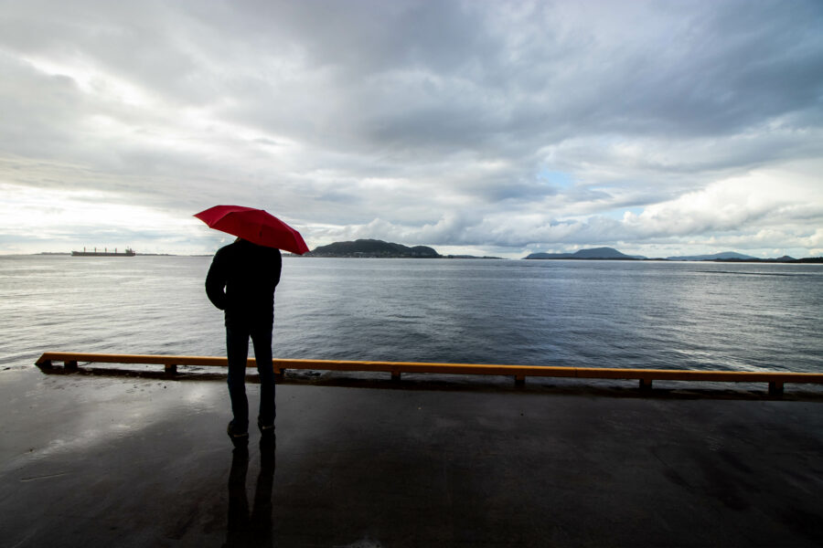 Ålesund havn. Mann med paraply.