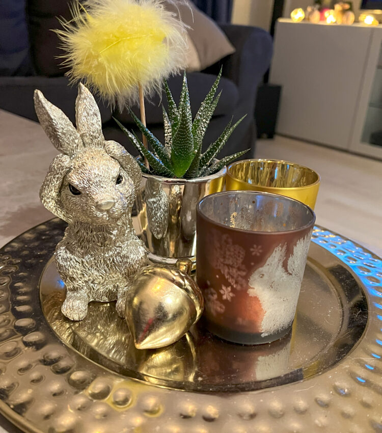 Easter decoration on the table: Light holders and a silver rabbit