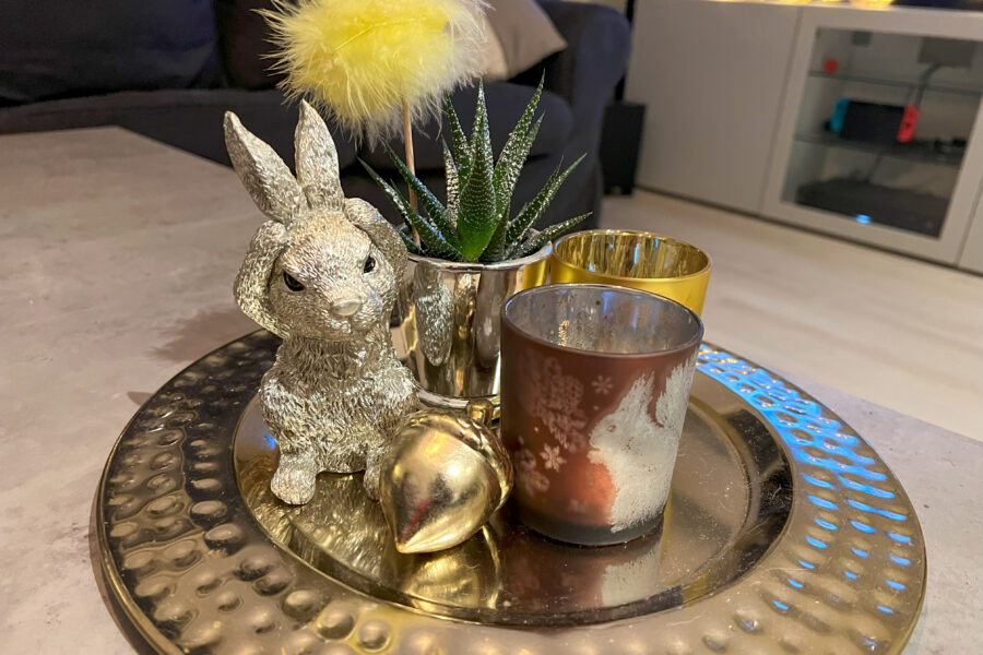 Easter decoration on the table: Light holders and a silver rabbit