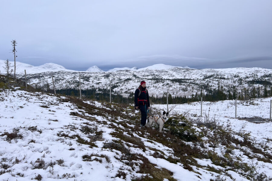 Jeg og Cassie med snølagte fjell bak oss